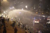 Israeli police use a water cannon to disperse demonstrators blocking a highway during a protest against plans by Prime Minister Benjamin Netanyahu's government to overhaul the judicial system in Tel Aviv, Israel, Monday, March 27, 2023. Tens of thousands of Israelis have poured into the streets across the country in a spontaneous outburst of anger after Prime Minister Benjamin Netanyahu abruptly fired his defense minister for challenging the Israeli leader's judicial overhaul plan. (AP Photo/Oren Ziv)