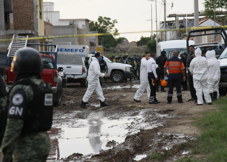 Miembros de la Guardia Nacional e investigadores forenses trabajan el miércoles 1 de julio de 2020 cerca de un centro de rehabilitación contra adicciones en Irapuato, México, luego de que hombres armados abrieran fuego en el interior y mataran a 24 personas. (AP Foto/Mario Armas)