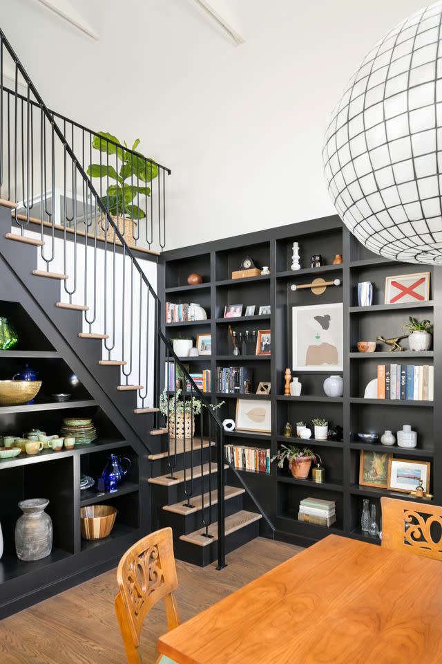 bookcases next to staircase in home designed by annie obermann of forge bow