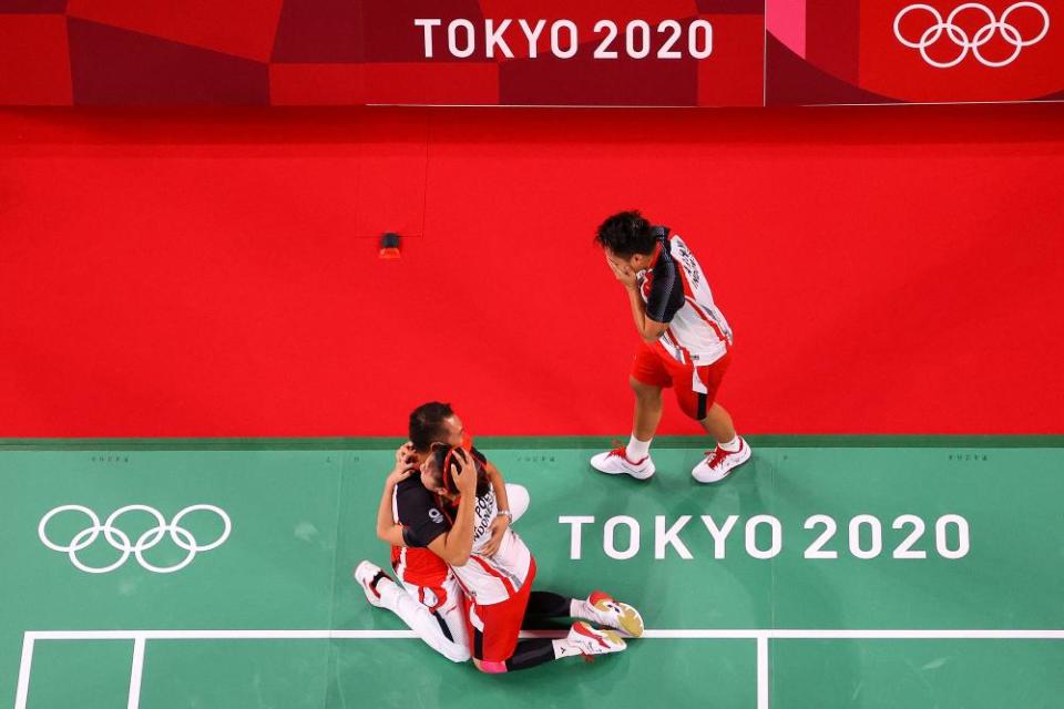 Greysia Polii (bottom right) and Apriyani Rahayu (top) of Indonesia celebrate with their coach Eng Hian.