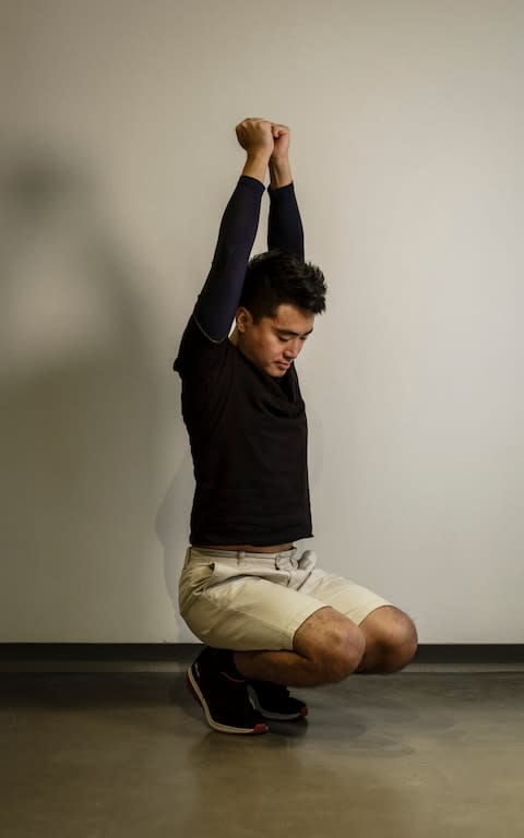 Simon Cheng demonstrates the different poses state security officers forced him to stand in for hours each day as part of the torture he endured while being interrogated - Credit: OLIVIER MARCENY