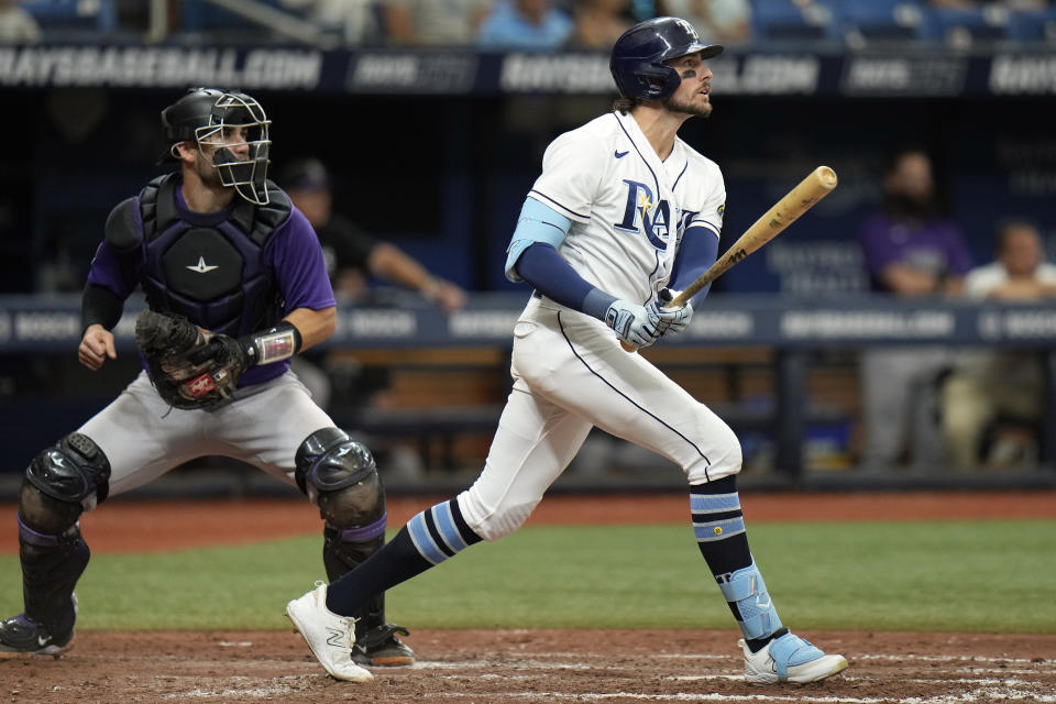 Tampa Bay Rays' Josh Lowe, right, watches his two-run home run off Colorado Rockies relief pitcher Matt Koch during the eighth inning of a baseball game Thursday, Aug. 24, 2023, in St. Petersburg, Fla. Catching for the Rockies is Austin Wynns. (AP Photo/Chris O'Meara)