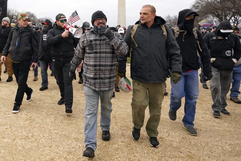 In this Jan. 6, 2021, photo, Proud Boys including Joseph Biggs, front left, walks toward the U.S. Capitol in Washington, in support of President Donald Trump. With the megaphone is Ethan Nordean, second from left. The Proud Boys and Oath Keepers make up a fraction of the more than 300 Trump supporters charged so far in the siege that led to Trump's second impeachment and resulted in the deaths of five people, including a police officer. But several of their leaders, members and associates have become the central targets of the Justice Department's sprawling investigation. (AP Photo/Carolyn Kaster)