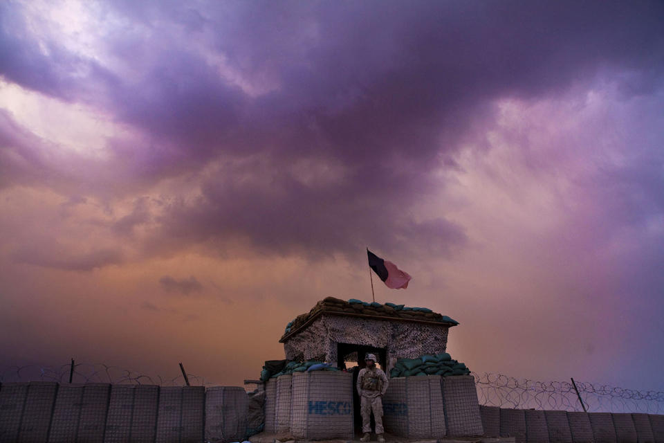 <p>A U.S. Marine from the First Battalion Eighth Marines Alpha Company looks out as an evening storm gathers above an outpost near Kunjak in southern Afghanistan’s Helmand province, Feb. 22, 2011. (Photo: Finbarr O’Reilly/Reuters) </p>