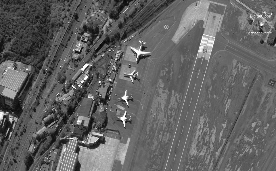 FILE - In this Dec. 10, 2018 file satellite image provided by DigitalGlobe shows the Simon Bolivar International Airport shortly after four Russian military aircraft arrived in Maiquetia, Venezuela. What the U.S. considers Russia’s destabilizing support for Venezuelan President Nicolas Maduro hit a high point in December when two Russian bombers capable of carrying nuclear weapons, bottom of photo, touched down in Caracas. (DigitalGlobe, a Maxar company via AP, File)