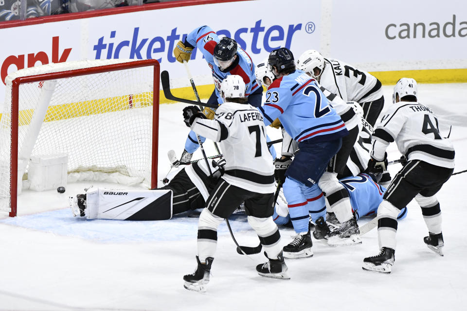 Winnipeg Jets' Cole Perfetti (91) scores on Los Angeles Kings goaltender Cam Talbot, back left, during the first period of an NHL hockey game in Winnipeg, Manitoba, on Monday, April 1, 2024. (Fred Greenslade/The Canadian Press via AP)