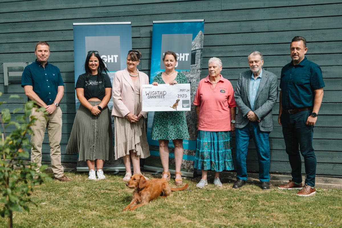 WightAID donors Paul Thomas (far left), of Isle of Wight Tomatoes and Paul Thorley (far right), of Vehicle Consulting Solent with representatives of some of the grant recipients, and Mavis, the WightAID dog <i>(Image: Robertson Foster)</i>