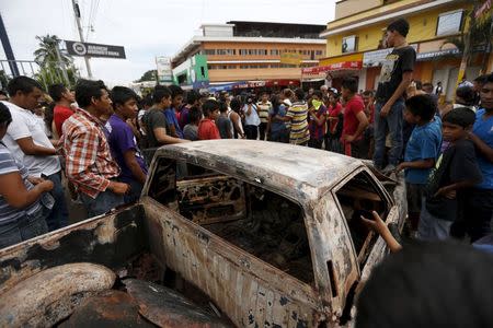 Villagers stand around a car burned previously during a protest against the re-election of the city's mayor Rubelio Recinos of the Patriot Party, in Barberena, northwest of Guatemala City, September 8, 2015. REUTERS/Jorge Dan Lopez