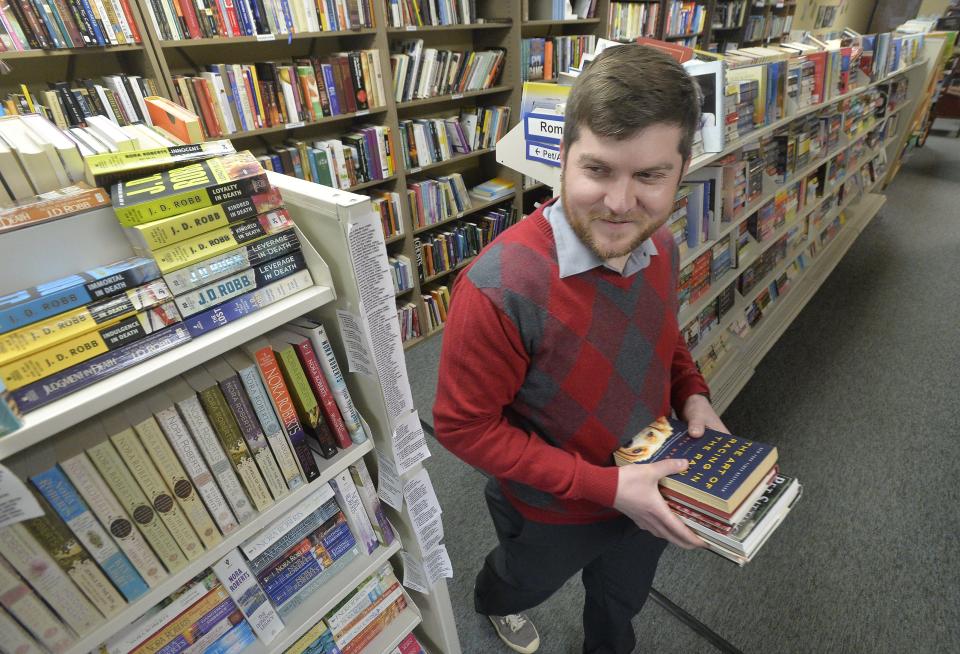 Kyle Churman, the new owner of Werner Books, sorts books at the Liberty Plaza shop in Erie on March 22, 2022. Churman, 34, and his wife Lauren Shoemaker, 34, are partners in the new venture.