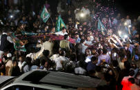 A vehicle carrying former Pakistani Prime Minister Nawaz Sharif is surrounded by his supporters, some throwing rose petals, following his release from prison in Rawalpindi, Pakistan, Wednesday, Sept. 19, 2018. The Islamabad High Court on Wednesday set him and his daughter and son-in-law free on bail pending their appeal hearings. The court made the decision on the corruption case handed down to the Sharifs by an anti-graft tribunal earlier this year. (AP Photo/Anjum Naveed)