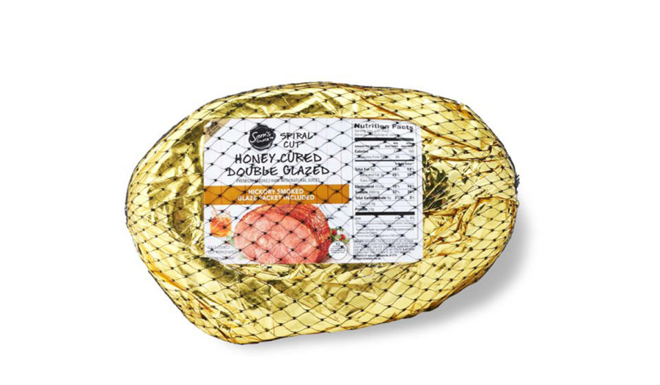 Package of gold foil wrapped honey cured double glazed ham with black netting around the package. 