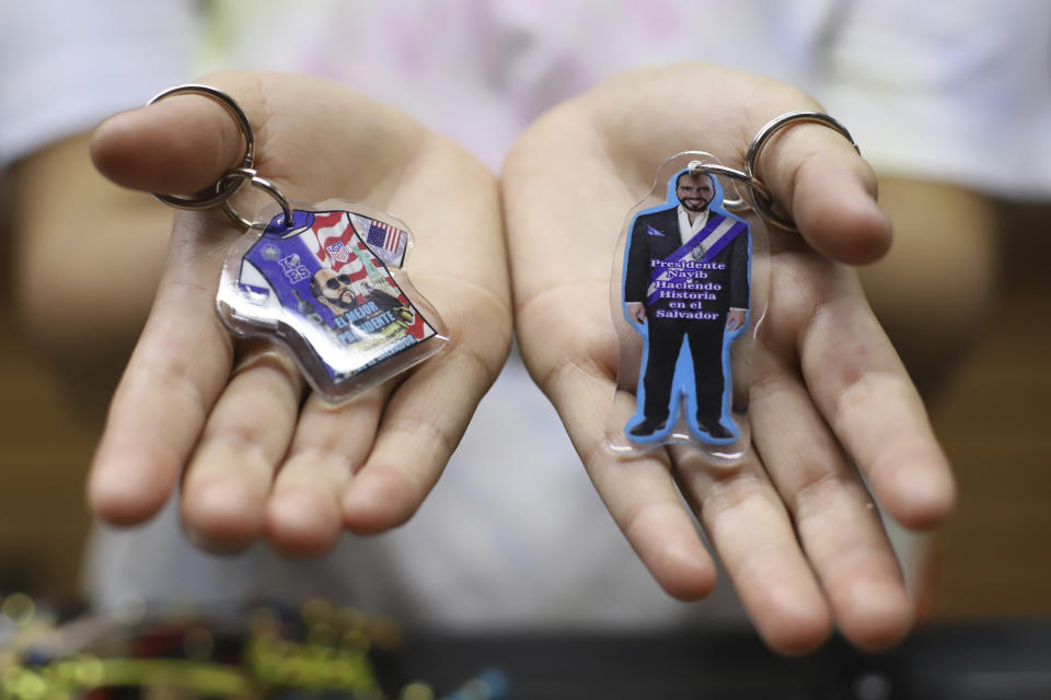A vendor shows off key chains depicting President Nayib Bukele, who is running for re-election, inside a handicraft shop central, in San Salvador, El Salvador, Wednesday, Jan. 24, 2024. El Salvador will hold a general election on Feb. 4 where voters will elect a president, vice president and members of Congress. (AP Photo/Salvador Melendez)