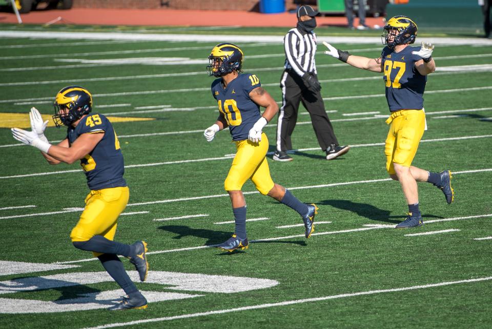 Adam Shibley (45) of the Michigan Wolverines, Anthony Solomon (10) of the Michigan Wolverines and Aidan Hutchinson (97) of the Michigan Wolverines celebrate after Michigan State Spartans missed a field goal during the fourth quarter at Michigan Stadium on Oct. 31, 2020, in Ann Arbor, Michigan.