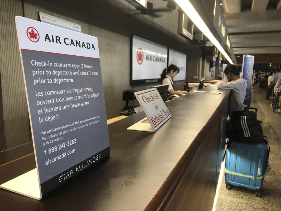 Passengers from an Australia-bound Air Canada flight diverted to Honolulu Thursday, July 11, 2019, after about 35 people were injured during turbulence, stand in line at the Air Canada counter at Daniel K. Inouye International Airport to rebook flights. Air Canada said the flight from Vancouver to Sydney encountered "un-forecasted and sudden turbulence," about two hours past Hawaii when the plane diverted to Honolulu. (AP Photo/Caleb Jones)