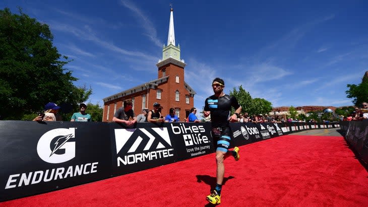 An athlete runs to the finish after accurately estimate triathlon finish time.