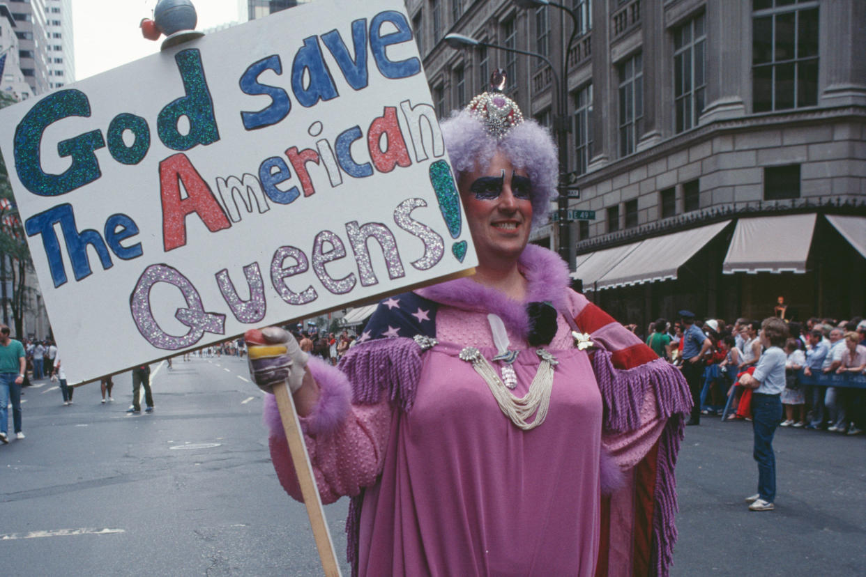 A drag queen holding a placard reading 'God save the American queens!' during the Pride Parade in New York City, June 1983.