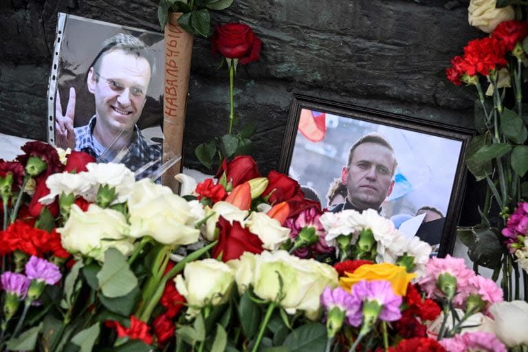 Fotografías del fallecido líder de la oposición rusa Alexei Navalny se exhiben junto a flores en el monumento a las víctimas de la represión política en Moscú el 17 de febrero de 2024, un día después de la muerte de Navalny en una prisión del Ártico. (Foto de Alexander Nemenov AFP)