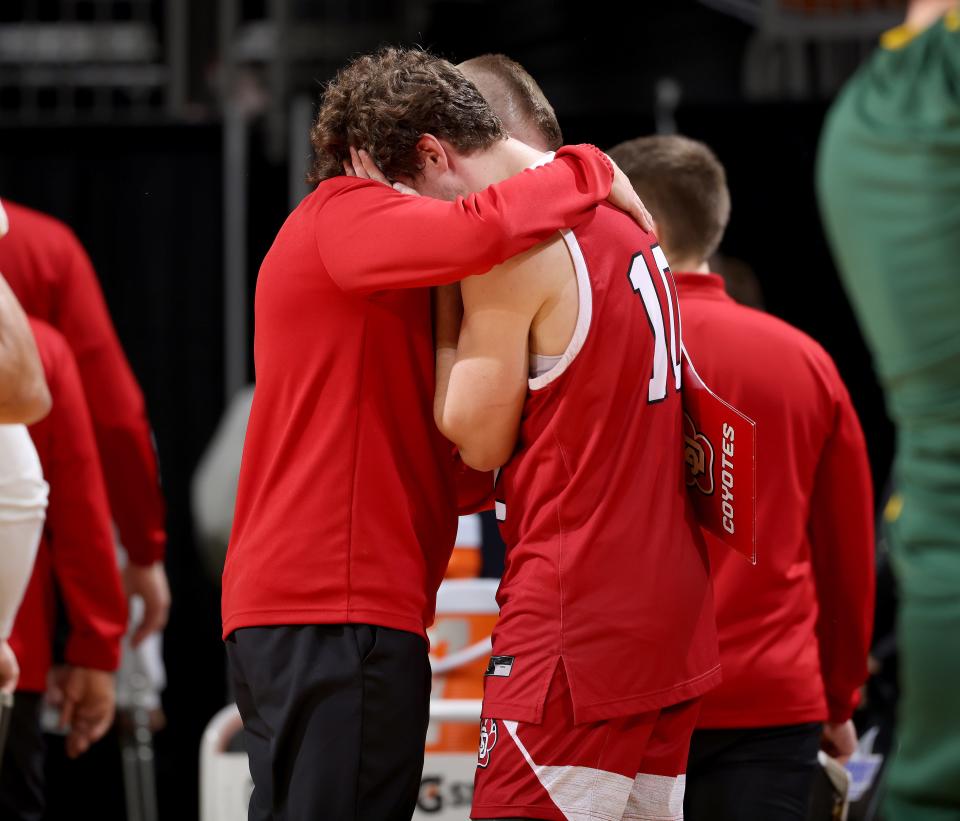 A.J. Plitzuweit #10 of the South Dakota Coyotes hugs coach after tough loss against the North Dakota State Bison, 68-70, at the 2023 Summit League Basketball Championship at the Denny Sanford Premier Center in Sioux Falls, South Dakota. (Photo by Dave Eggen/Inertia)