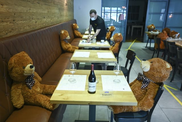 Manager Musa Gezer prepares tables in his restaurant Beef’n Beer besides big teddy bears in Hofheim, Germany. In order to ensure social distancing (Arne Dedert/AP)