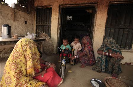 Female members of the Hindu community sit with their children at a house in the small town of Amangarh, located in Pakistan's Rahim Yar Khan District, March 26, 2014. REUTERS/Faisal Mahmood