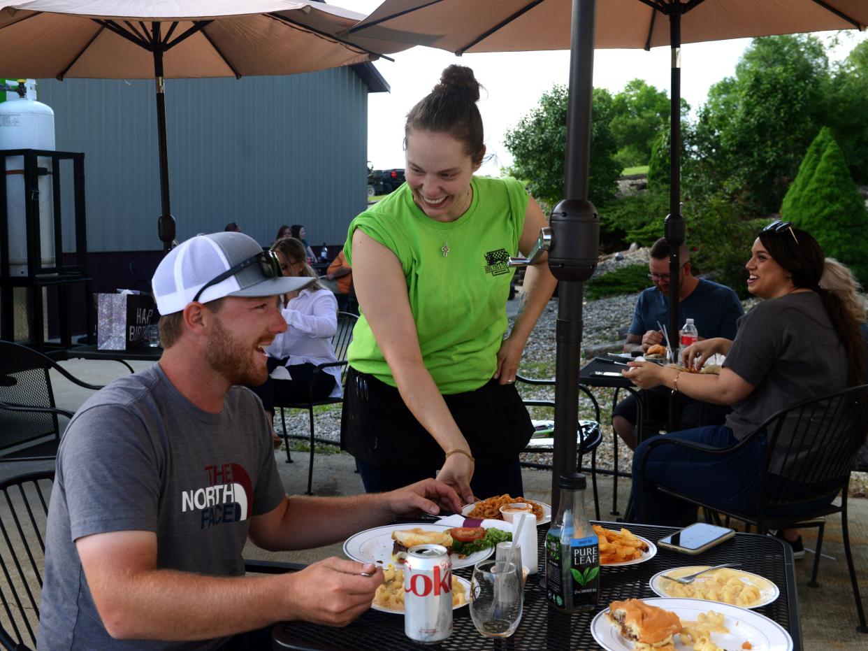 Brittany Conley serves food to customers for the Horns, Fins & Feathers food truck on May 28 at Stone Crest Vineyard and Winery. The widely popular food truck, owned by Zanesville's Kem Gibson and Brian Waller, specializes in fresh meat and seafood not often seen in food trucks. 