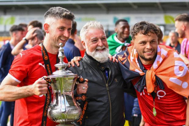 Former York City chairman Jason McGill (centre) holds the Vanarama National League North play-off final trophy with players Paddy McLaughlin (left) and Kurt Willoughby (right). Picture: Tom Poole