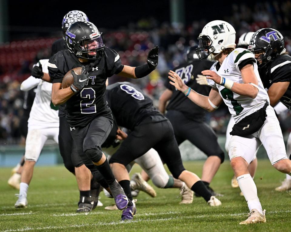 Blackstone Valley Tech's Josh Mateo fends off Nipmuc's Oscar Clark (right) en route to a first-half touchdown during the Thanksgiving Eve rivalry game at Fenway Park, Nov. 24, 2021.