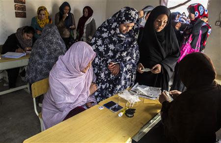 Afghan women wait to receive their voter cards at a voter registration centre in Kabul March 30, 2014. Afghan presidential elections will be held on April 5. REUTERS/Zohra Bensemra