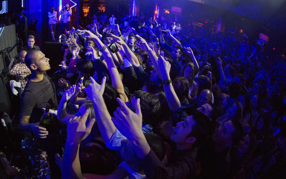 DJ Afrojack, left, holds a champagne bottle as he prepares to spray a crowd of revelers while performing at the XS nightclub in Las Vegas on Sunday, Jan. 20, 2013. (AP Photo/Julie Jacobson)