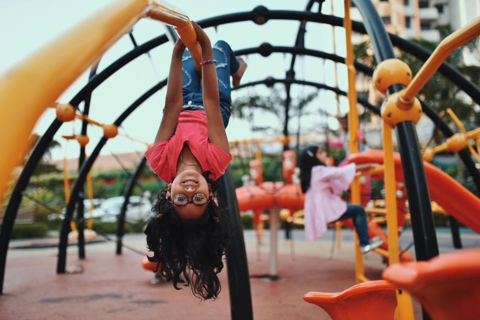 Girl upside down on the jungle gym