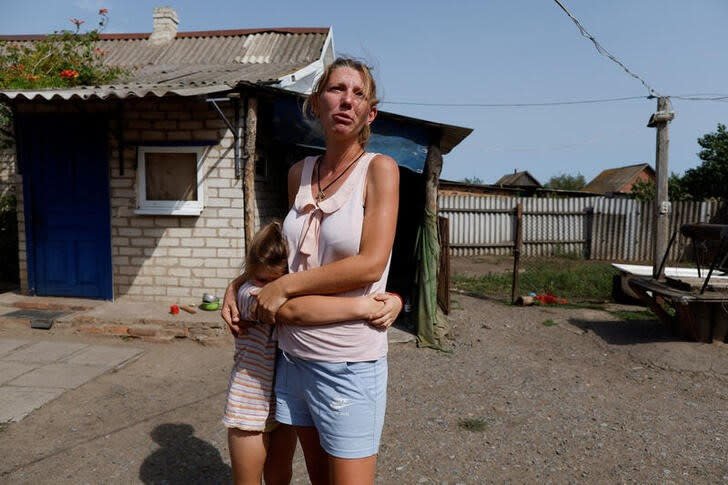 La ucraniana Olga abraza a su hija mientras lloran cerca de su casa en la aldea de Pereizne, Ucrania.