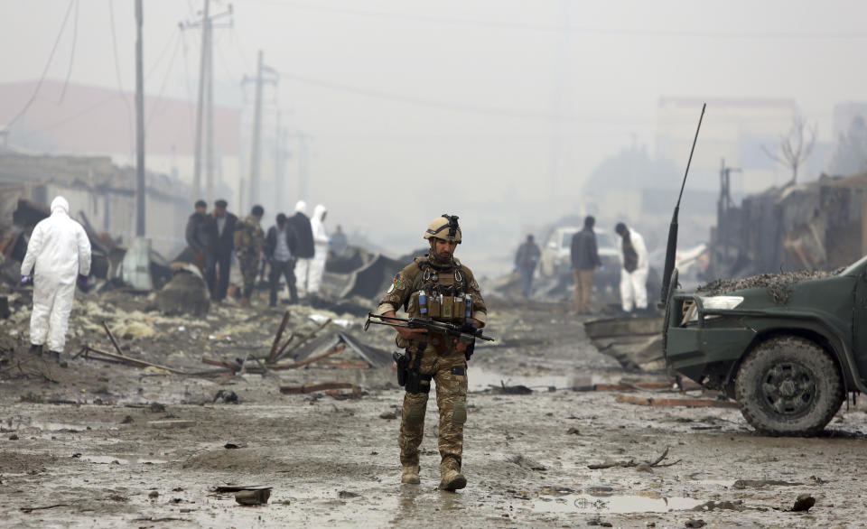 An Afghan security force walks around the site of suicide bomb attack in Kabul, Afghanistan.