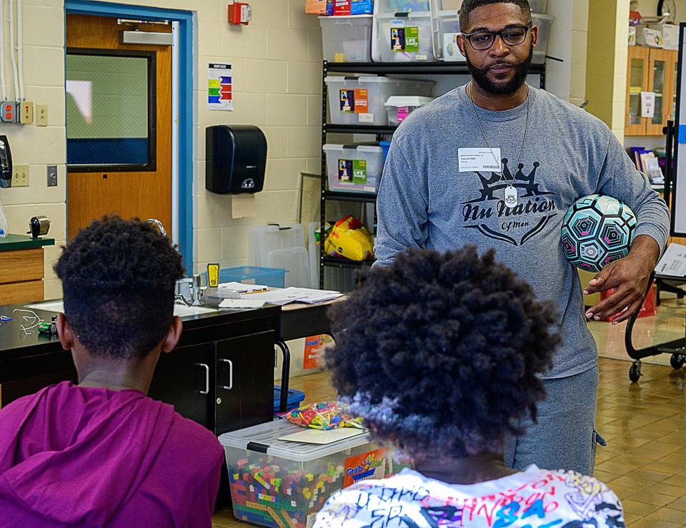 Mark James Jr. speaks with students in a classroom at The Webster School in West Augustine, where he volunteers, on Friday, Dec. 3, 2021. James,  a corrections officer for the St. Johns County Sheriff's Office, is a finalist for USA TODAY'S inaugural Best of Humankind awards.
