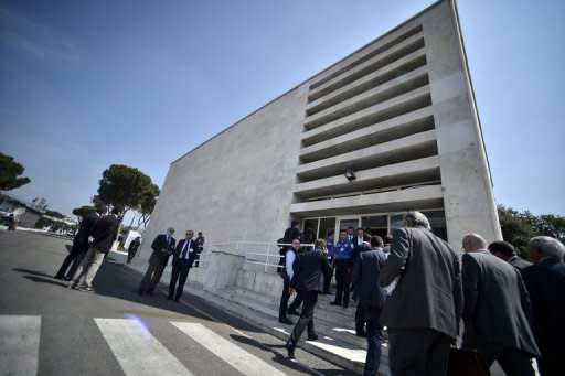 People are seen walking towards the building where a trial organized by the Italian football federation (FIGC) takes place, on May 31, in Rome. 54 football players and 22 clubs will be scrutinised until June 4 or 5, in matchfixing cases