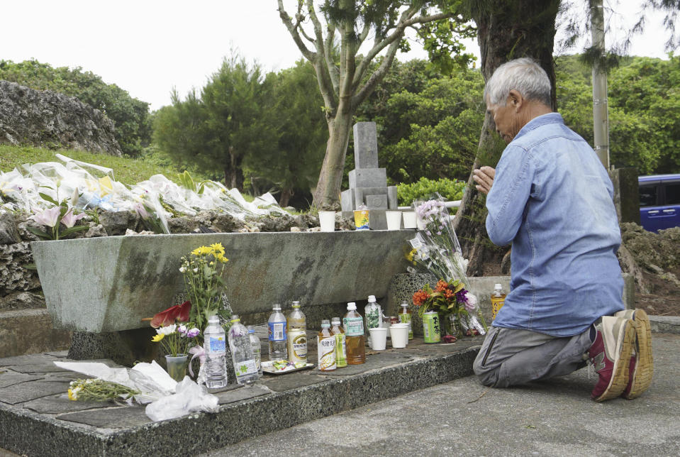 A man pays in front of a memorial containing the remains of unidentified persons at the Peace Memorial Park in Itoman, Okinawa prefecture, southern Japan Friday, June 23, 2023. Japan marked the Battle of Okinawa, one of the bloodiest battles of World War II fought on the southern Japanese island, which ended 78 years ago. (Kyodo News via AP)