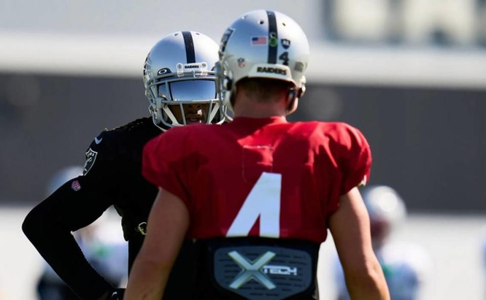 Las Vegas Raiders’ Derek Carr and Davante Adams discuss a play during a joint practice with the New England Patriots on Tuesday, Aug. 23, 2022.