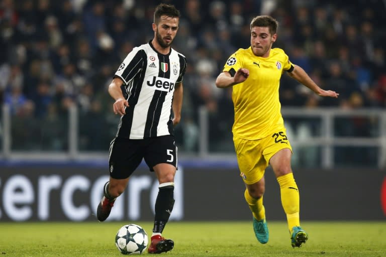 Juventus' midfielder Miralem Pjanic (L) fights for the ball with Dinamo's forward Bojan Knezevic during the UEFA Champions League football match Juventus Vs GNK Dinamo Zagreb on December 7, 2016