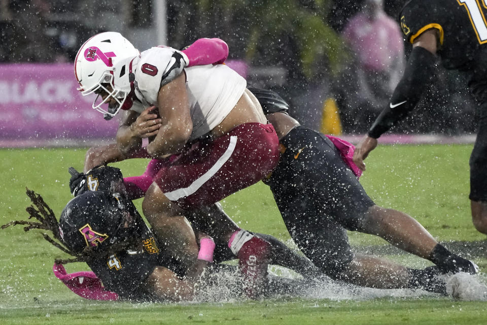 Miami (Ohio) running back Rashad Amos (0) runs for a first down as Appalachian State safety Nick Ross (4) makes the tackle during the first half of the Cure Bowl NCAA college football game, Saturday, Dec. 16, 2023, in Orlando, Fla. (AP Photo/John Raoux)