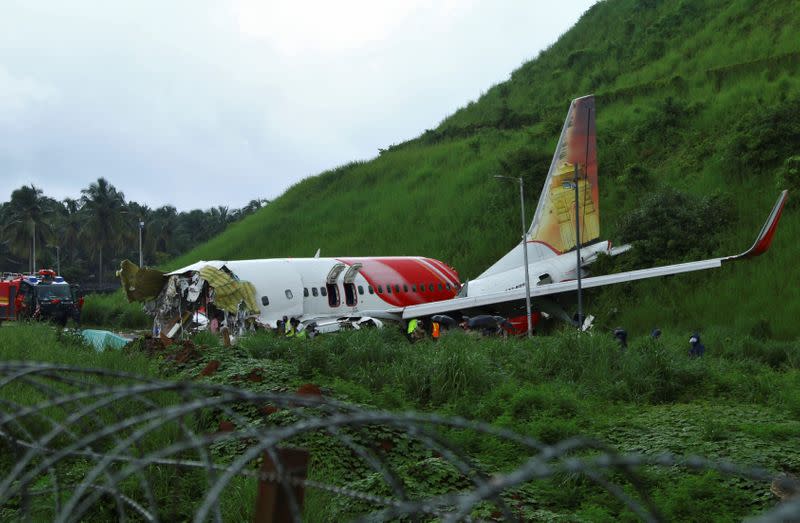 Officials inspect the site where a passenger plane crashed when it overshot the runway at the Calicut International Airport in Karipur