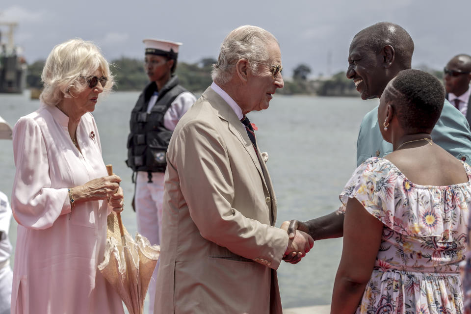 Britain's King Charles III, center, followed by Queen Camilla, is welcomed by Kenyan President William Ruto and First Lady Rachel Ruto upon their arrival to meet Royal Marines and Kenyan Marines at Mtongwe Naval Base, in Mombasa, Kenya, Thursday, Nov. 2, 2023. (Luis Tato/Pool Photo via AP)