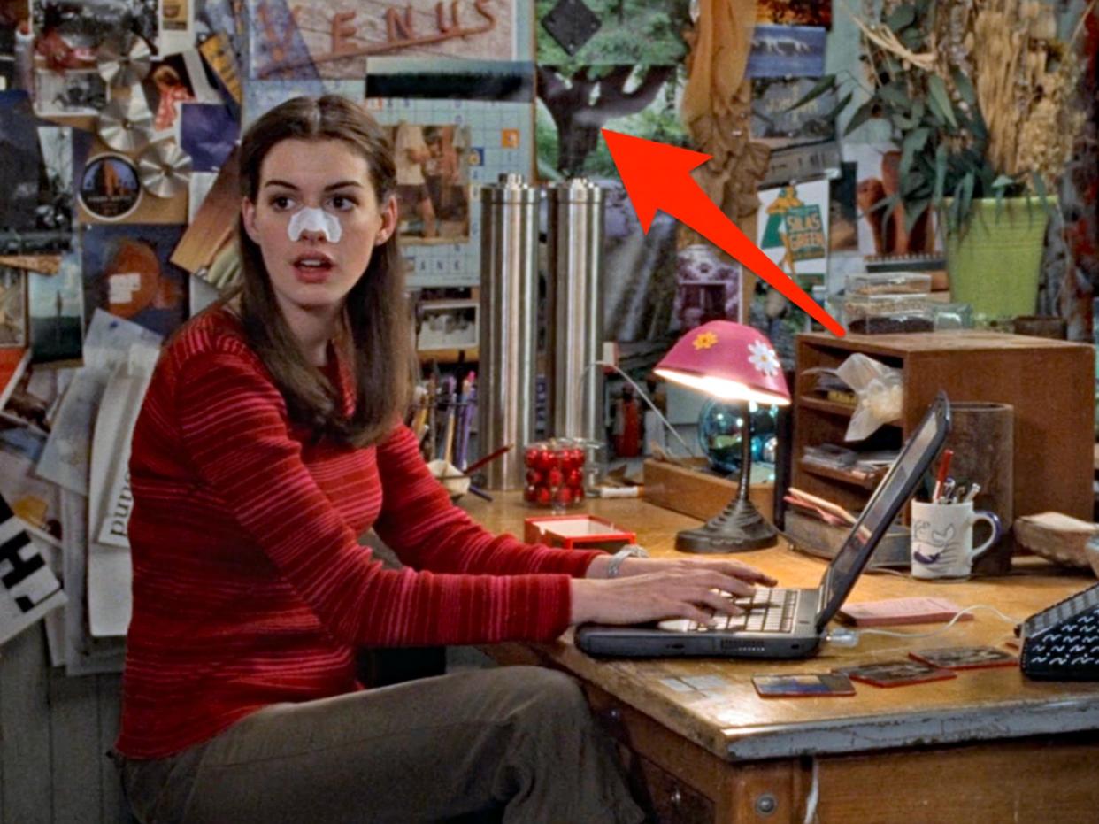 mia sitting at her desk with a laptop wearing a pore strip on her nose in princess diaries