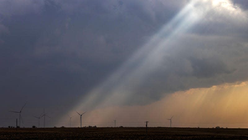 Sunlight filters through storm clouds onto a wind turbine as severe weather rolls through the midwest on Tuesday, April 4, 2023, south of Stuart, Iowa. 