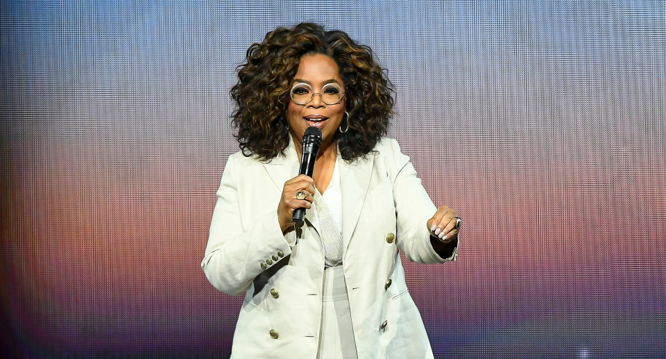 oprah standing with microphone on stage against blue and purple screen, Oprah's 2022 Favourite Things list