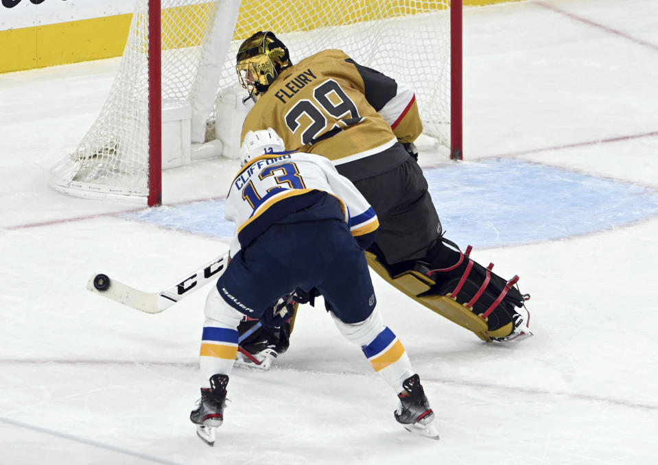 Vegas Golden Knights goaltender Marc-Andre Fleury (29) comes out of the crease to block the puck next to St. Louis Blues left wing Kyle Clifford (13) during the second period of an NHL hockey game Saturday, May 8, 2021, in Las Vegas. (AP Photo/David Becker)