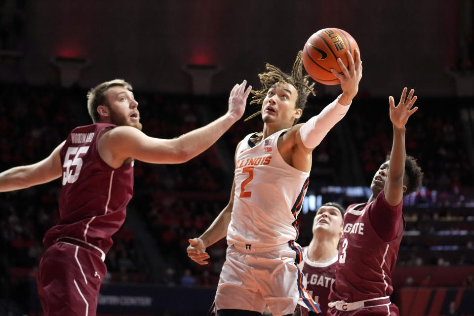 Illinois' Dra Gibbs-Lawhorn drives the the basket between Colgate's Jeff Woodward (55) and Jalen Cox during the first half of an NCAA college basketball game Sunday, Dec. 17, 2023, in Champaign, Ill. (AP Photo/Charles Rex Arbogast)