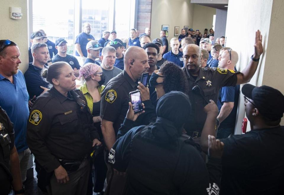 Supporters of Patrick Lyoya and supporters of Christopher Schurr are separated by Kent County Sheriff deputies in the hallway outside of Kent County District Court as Grand Rapids Police officer Schurr appeared on video from jail, Friday, June 10, 2022 in Grand Rapids, Mich. (Joel Bissell/The Grand Rapids Press via AP)