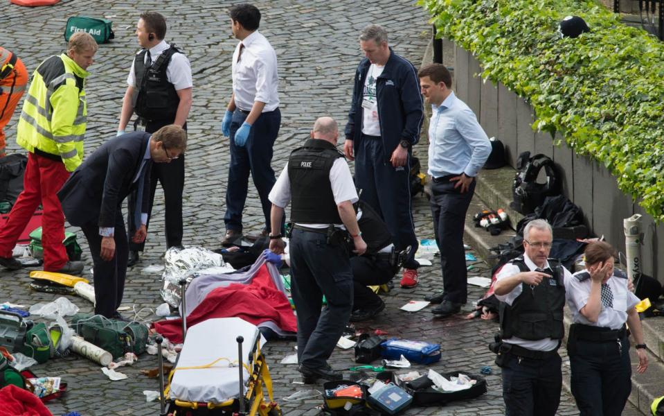 Conservative MP Tobias Ellwood (left) stands amongst the emergency services at the scene outside the Palace of Westminster - Credit: Stefan Rousseau/PA