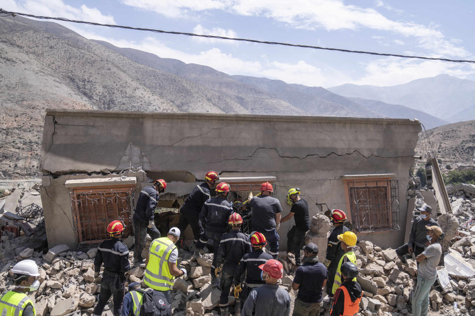 A rescue team attempt to recover the body of a woman who was killed by the earthquake, in the town of Imi N'tala, outside Marrakech, Morocco, Tuesday, Sept. 12, 2023. (AP Photo/Mosa'ab Elshamy)