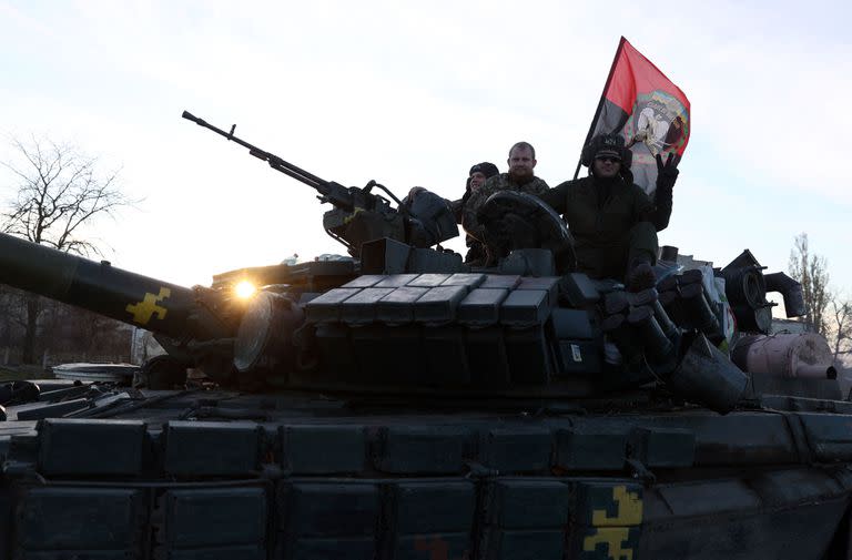 Soldados ucranianos saludan a la gente mientras recorren una carretera en la región de Kherson el 14 de noviembre de 2022, en medio de la invasión rusa de Ucrania.