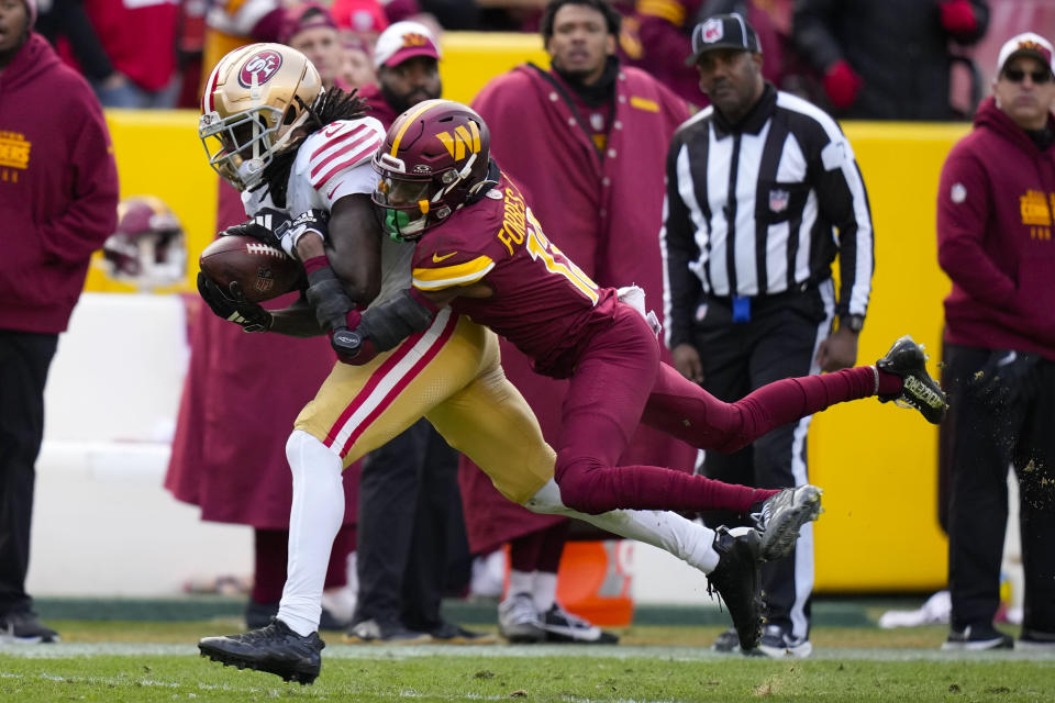 San Francisco 49ers wide receiver Brandon Aiyuk (11) makes a catch against Washington Commanders cornerback Emmanuel Forbes (13) during the second half of an NFL football game, Sunday, Dec. 31, 2023, in Landover, Md. (AP Photo/Alex Brandon)